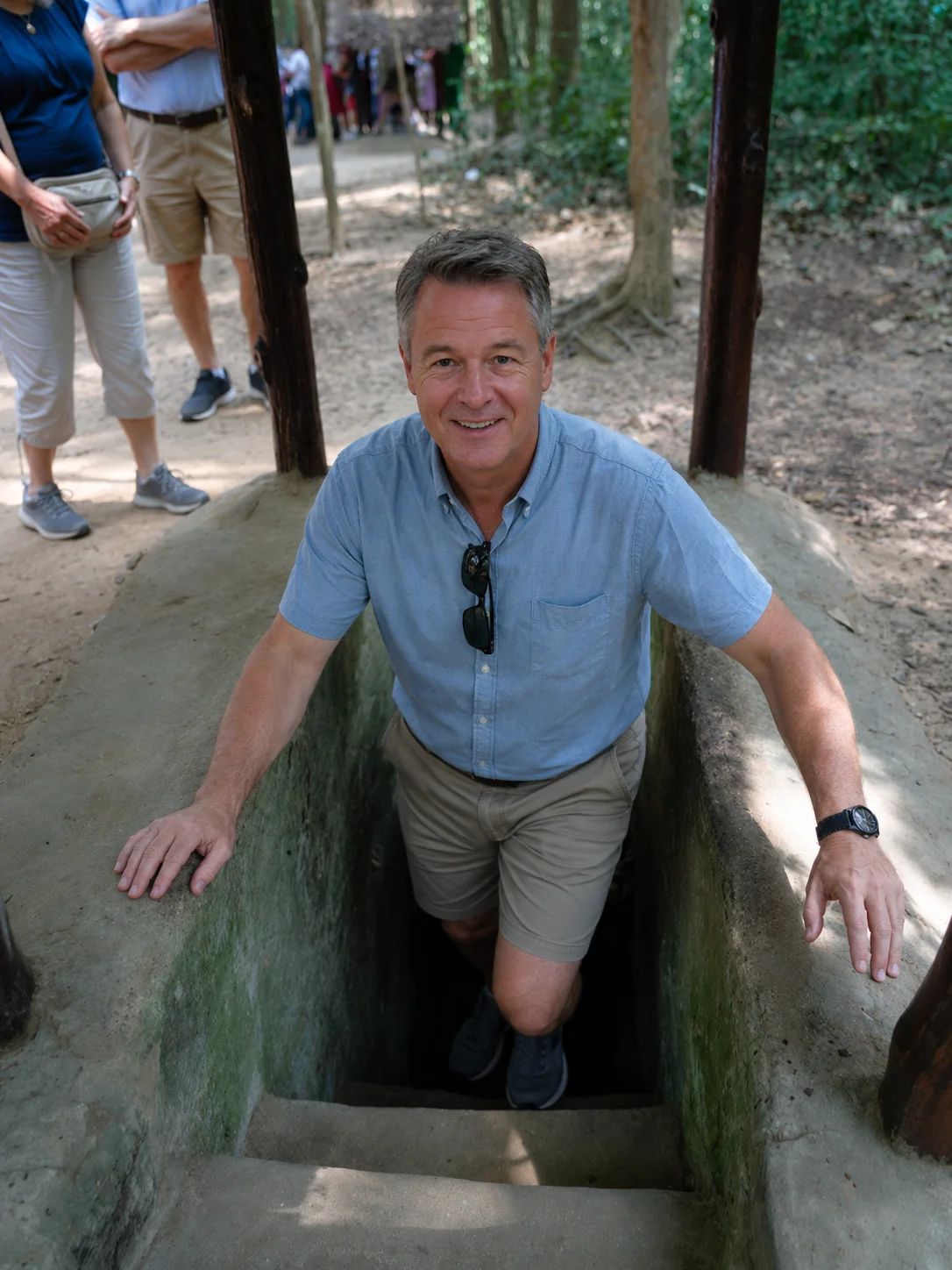 Traveller at the entrance to a preserved Củ Chi tunnel
